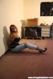 Gag taped blonde chick in jeans gets hogtied and dropped facedown to the floor