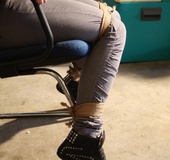 Fill dresses brunette with a cleavegag bound to a chair struggling to