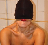 Poor naked girl with a stick in her mouth and a hat on her eyes gets hogtied