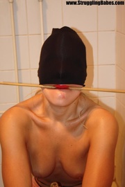 Poor naked girl with a stick in her mouth and a hat on her eyes gets hogtied and dropped to the floor