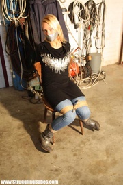 Blonde girl in jeans gets tightly roped to the chair with her mouth gagtaped