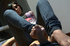 Nasty fully dressed chick in sunglasses giving a footjob to a dude in