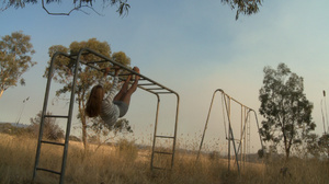 Long-haired blonde chick in a striped blouse swinging on the swings and then fingering her cooch in the field - Picture 1