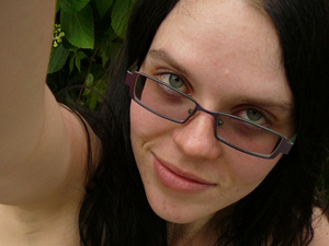 Brunette chick in glasses trying to take her own picture on mobile - Picture 5