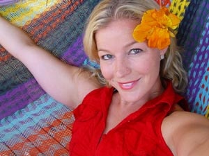 Sexy blonde mom in a red dress and with a flower in her hair shooting herself - Picture 2