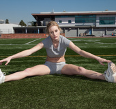 Fair-haired busty athletic girl in trainers and sexy uniform flexing her