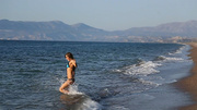 Pretty teen in blue bikini undresses to swim naked in the sea