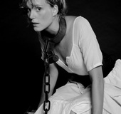 Hot babe in a modest dress posing in collar and chain for cool black and