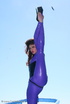Flexible brunette in lilac latex and stilettos gets topless