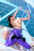 Flexible brunette in lilac latex and stilettos gets topless