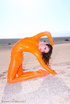 Brunette in orange latex jumpsuit shows her perfect titties