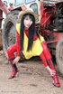 Black haired babe in red latex posing with a tractor