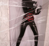 Sexy brunette in black latex jumpsuit takes on red mask