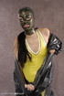 Masked girl in yellow latex comes out of a black sack and reveals her