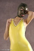 Masked girl in yellow latex comes out of a black sack and reveals her