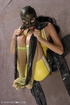Masked girl in yellow latex comes out of a black sack and reveals her