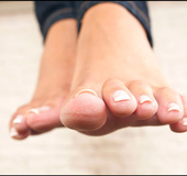 Beautiful seductress bewitches with her big feet in sexy tan nylon socks