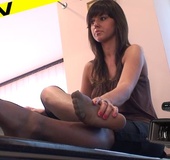 Charming brunette stretches and rubs her wide soles in grey nylons