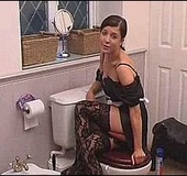 Ponytailed brunette in sexy corset and stockings fingering her cunt