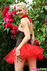 Sexy naughty blonde in pretty red and black dress enjoys looking sexy