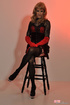 Sexy male chick combines red and black dress with pantyhose and boots