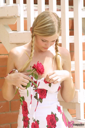 A gorgeous blond with red rose undressed topless in her red roses printed dress - Picture 2