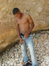 A lascivious young dark skinned latino sunbathing among the rocks and