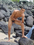A lusty bronzed latino twink poses nude for the camera showing the extra