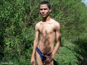A dark randy latino twink proudly showing his huge equally dark dick among the bushes and blasting cock juice all over his stomach - Picture 4