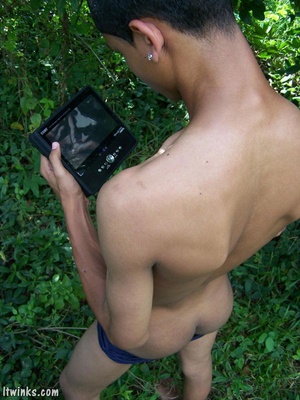 A dark randy latino twink proudly showing his huge equally dark dick among the bushes and blasting cock juice all over his stomach - Picture 9
