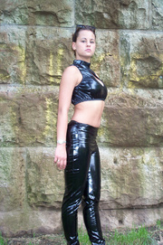 Sexy slim teen in black shinny leather outfit and hot glasses looks sweet outdoors