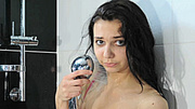 Attractive teen brunette all wet in the bathtub