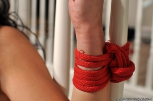 Sexy brunette with wrists bound to the banisters is gagged and apprehensive even with her legs unbound - Picture 11