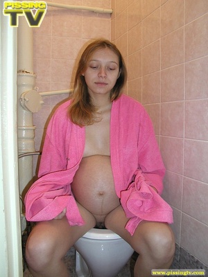 Luscious pregnant teen takes her seat in the toilet and lets out a steaming golden piss from her shaved pussy - Picture 6