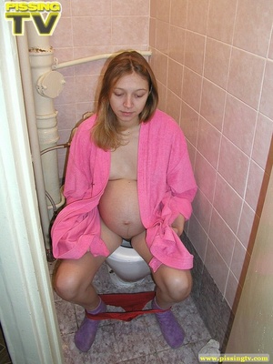 Luscious pregnant brunette teen takes her seat in the toilet and lets out a steaming golden piss from her shaved pussy - Picture 9