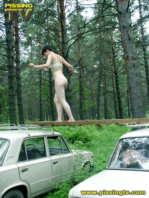 Daring brunette teen balances on a ladder proped on two cars, squats and relieves herself right there with out caring as to who is watching her - XXXonXXX - Pic 17