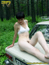 Daring brunette teen balances on a ladder proped on two cars, squats and