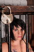 Short haired brunette slave wearing a fishnet body suit is kept inside
