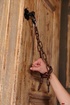 Lovely innocent teen is chained spreadeagle to a door frame wearing her