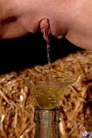 Sexy bitch with a shaved head is tied in a barn then is  made to piss into a bottle then the golden pee is poured back over her pussy and she was made to drink the rest of it - Picture 7