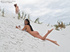 Frolicking in the sand are two hot and sexy brunettes with equally delicious