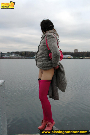 Babe walking outdoors makes a quick stop on an embankment to let out hot piss - Picture 8