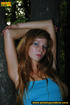 Redhead in blue raises her top and skirt to expose tits and piss outdoors