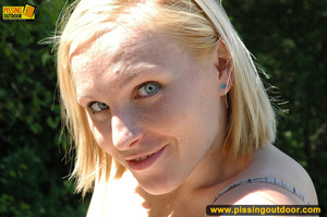 Cute blonde expose tits and pussy as she bends down to piss right on the road - Picture 11