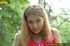 Cute chick sits on tree log in the woods and spreads legs to piss on magazine