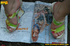 Cute chick sits on tree log in the woods and spreads legs to piss on magazine