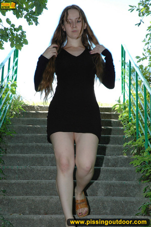 Smiling cute shapely chick in sexy black dress pisses along the park steps - XXXonXXX - Pic 1
