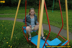 Hot young chick in public playground raise skirt and slide panty to piss on swing - Picture 3