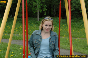 Hot young chick in public playground raise skirt and slide panty to piss on swing - Picture 4