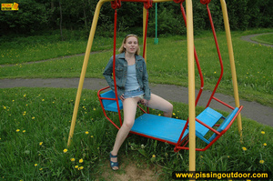 Hot young chick in public playground raise skirt and slide panty to piss on swing - Picture 12
